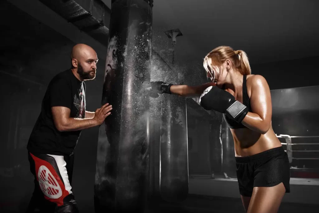 Mujer entrenando boxeo con saco y entrenador en gimnasio JaleaFit San Felipe